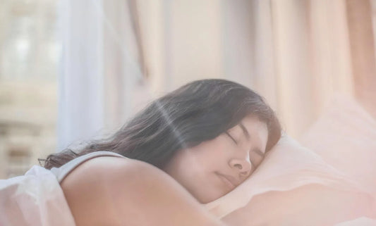 Young asian woman sleeping peacefully on soft pillow by sheer sunlit curtains.